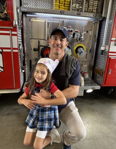 Justin Milmeister with his daughter in front of a fire truck-min
